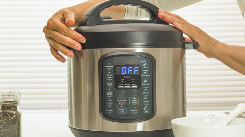 Hands turn Instant Pot lid