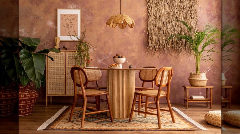 A rosy wallpaper hangs in a monochromatic bohemian eat-in kitchen area