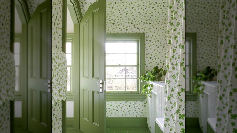 A clover patterned wallpaper covers the walls of a bathroom