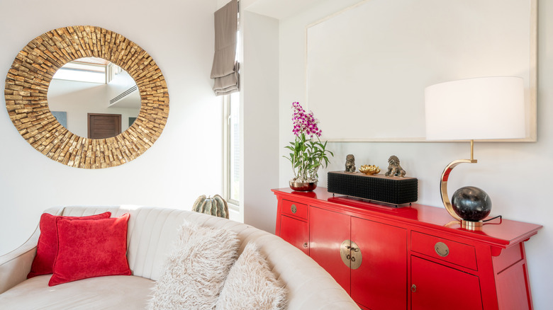 A white living room with a pop of red.
