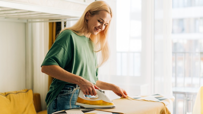 Woman smiling while ironing