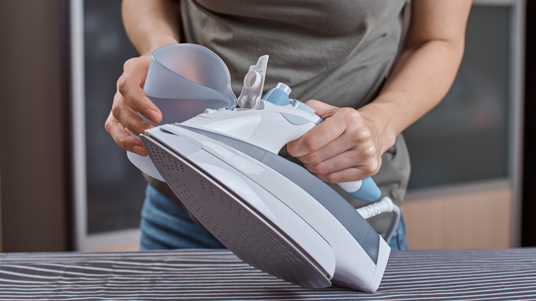Woman adding water to iron