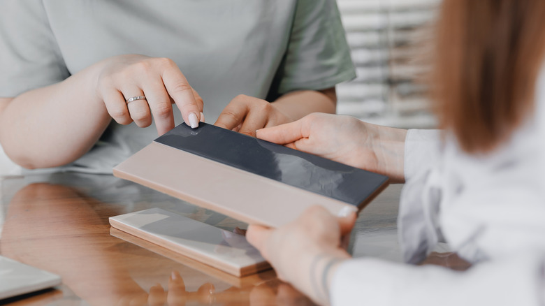 Inspecting patterned tile option for decorating.