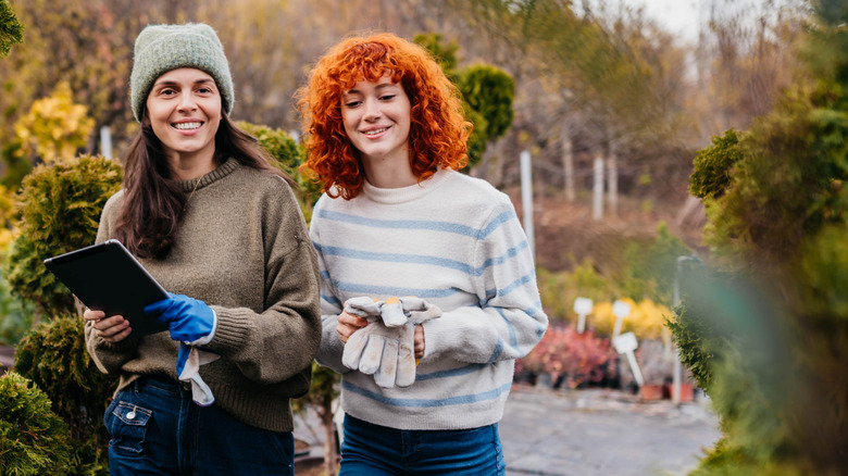 Two women shopping for shrubs at a nursery in winter