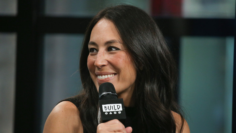 Joanna Gaines smiles while holding a microphone during an interview at Build Studio in New York City.