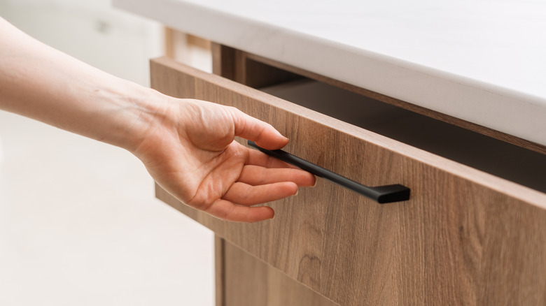 Woman opening wooden drawer