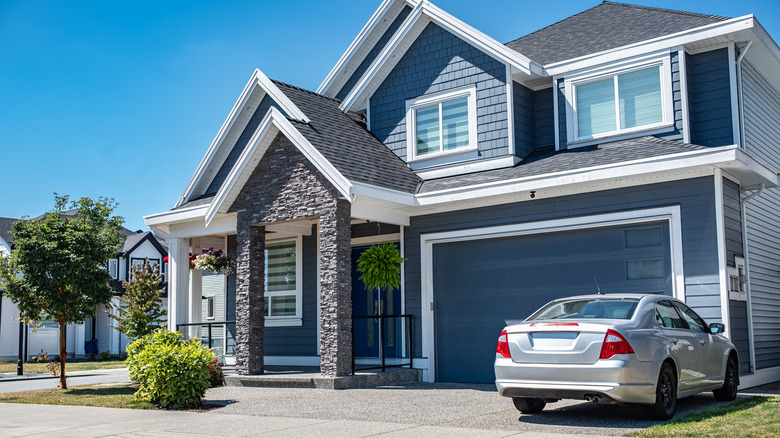 Modern house with a black slate roof and a silver car in the driveway