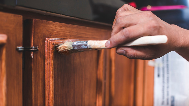 Person painting kitchen cabinets