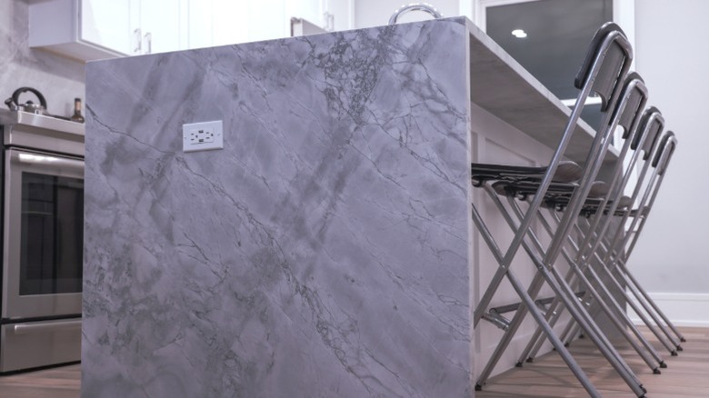 quartzite waterfall kitchen island counter with modern foldable barstools