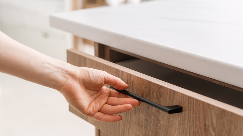 person opening a kitchen drawer