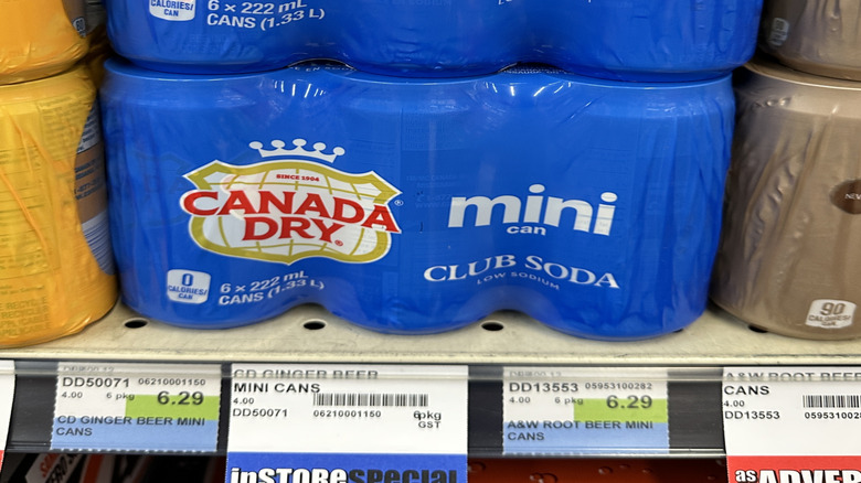 A mini can six-pack of Canada Dry club soda on the shelf in a supermarket.
