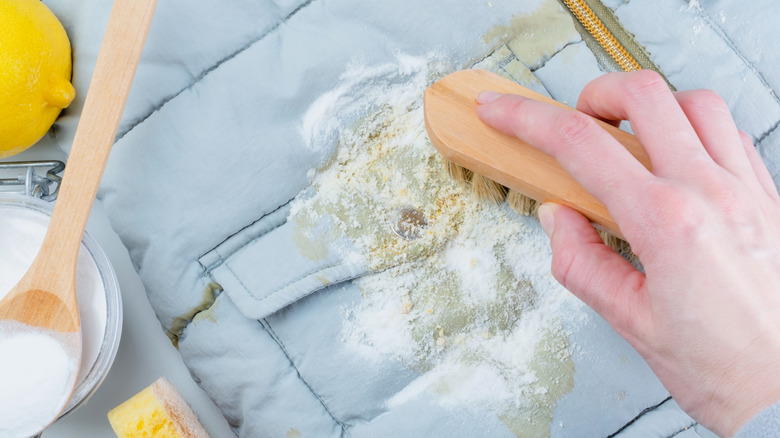 A person uses baking soda to treat a stain
