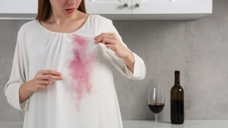 A red wine stain on a woman's white blouse.