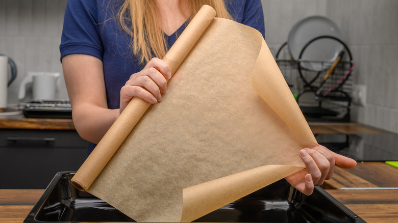 woman pulls out roll of wax paper