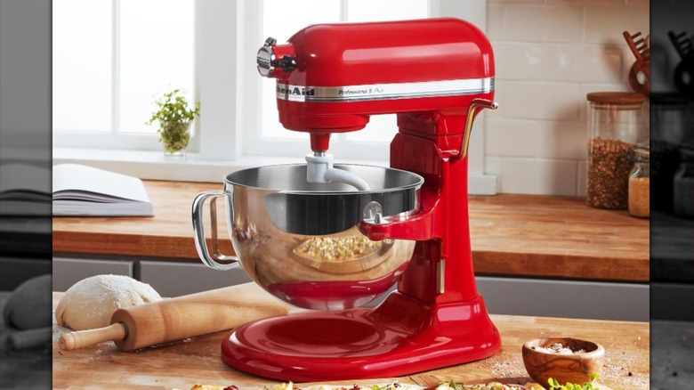 The red KitchenAid 6 Quart Bowl-Lift Stand Mixer on a butcher block countertop in a kitchen