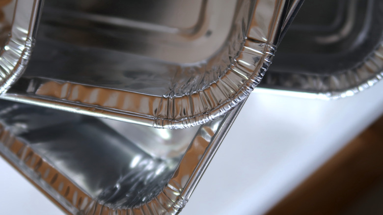 Several foil pans stacked on top of eachother on a counter