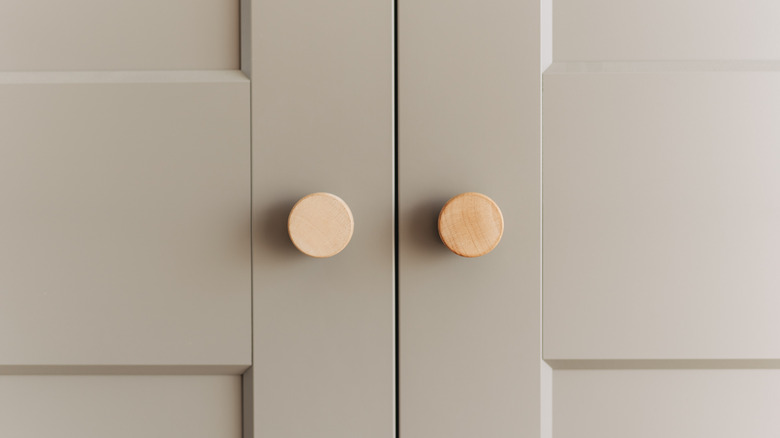 close up of two wooden knobs on grey cabinet