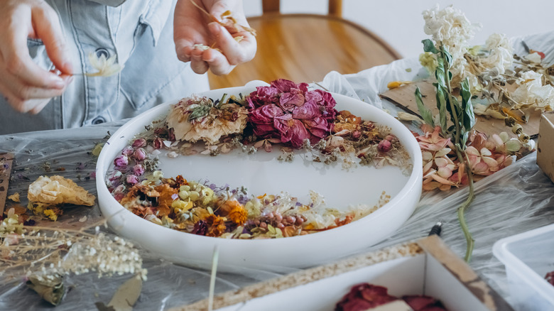 Woman arranging dried flowers in a mold