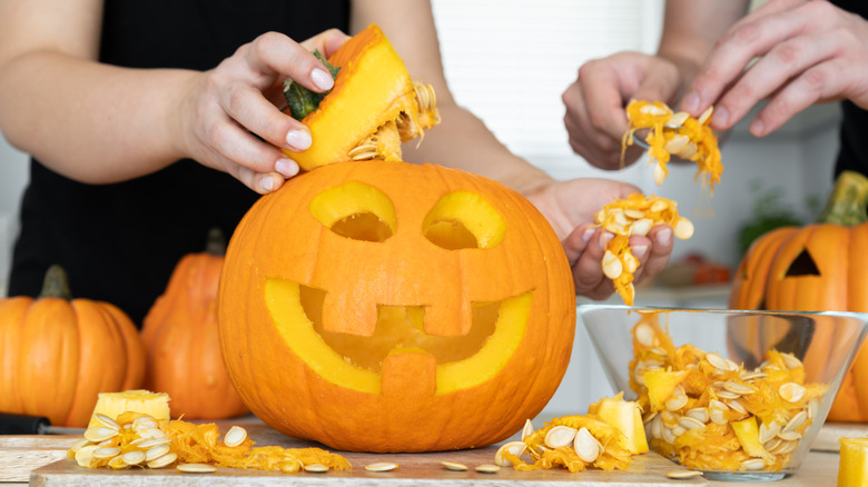 people carving a pumpkin