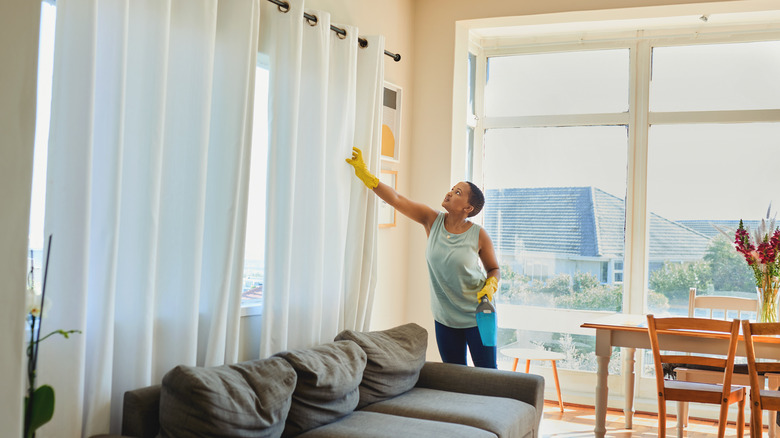 Woman cleaning curtains