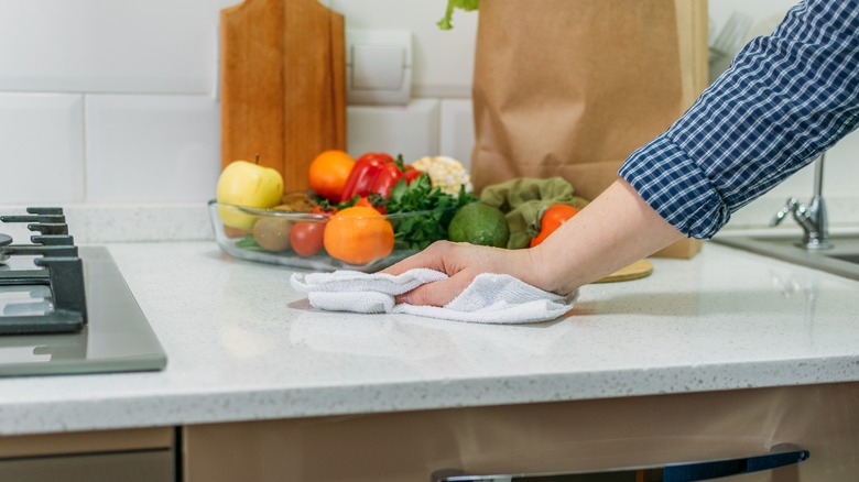 person wiping counter spill