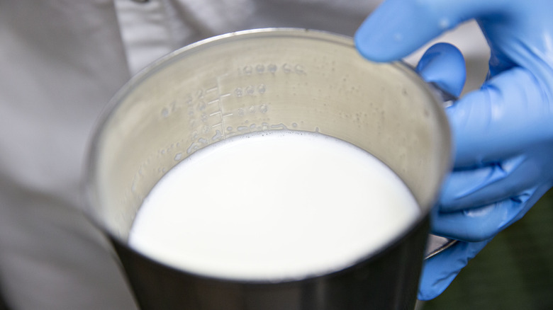 hand holding a container of milk