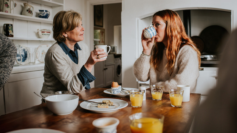 Women sipping tea and eating breakfast at a kitchen island