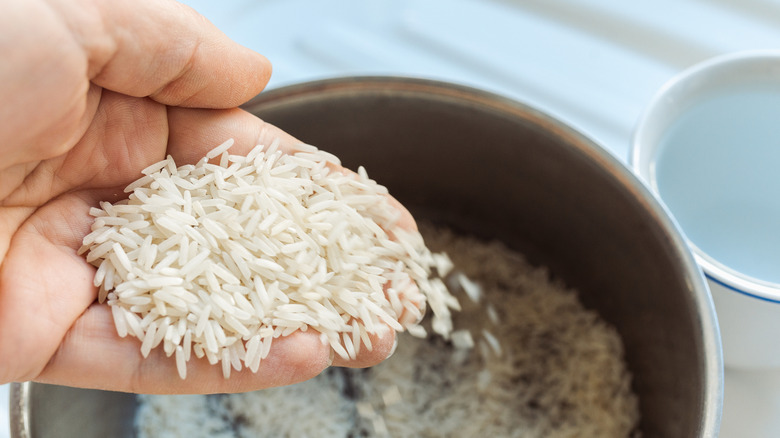 Close up of person rinsing rice to make rice water