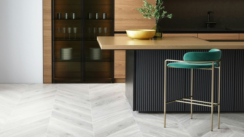 Fluted detailing on a kitchen island with a green bar stool next to it