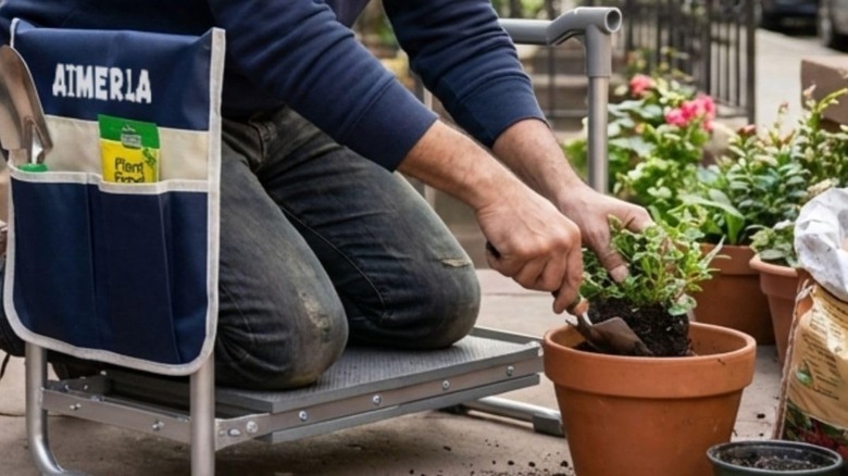 A man kneeling on a garden seat while potting flowers