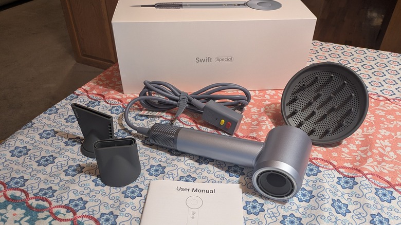 The Laifen Swift, its attachments, and users manual sit next to its box.