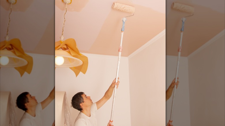 Man painting ceiling a darker pink than the walls