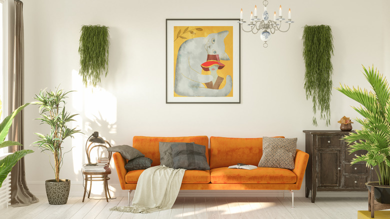 A white midcentury modern room with orange sofa