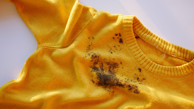 Rumpled yellow sweater with mud stain
