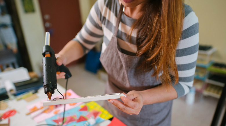 hand holding hot glue gun