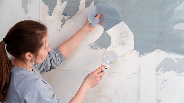 Person removing wallpaper