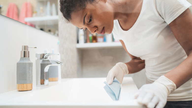 woman wiping down sink