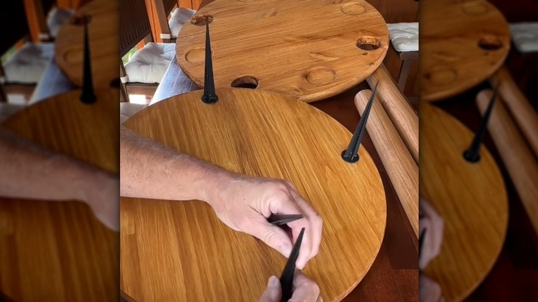 man putting stakes on bottom of lawn dining table to hold it in place