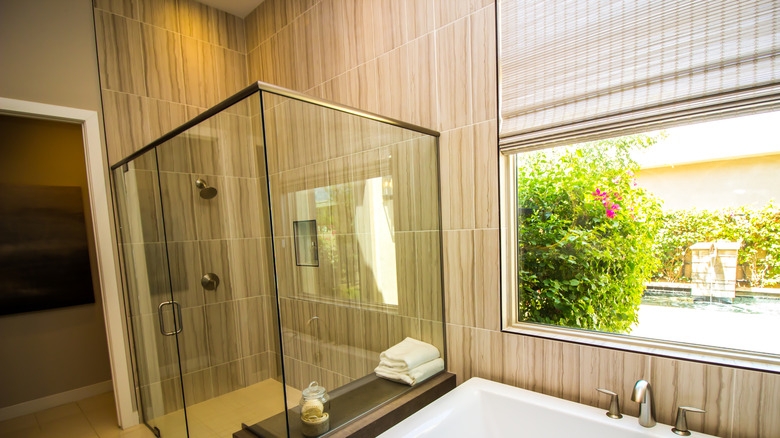 A bathroom features a woven wood window treatment