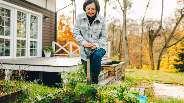 Woman digging in a garden bed in fall