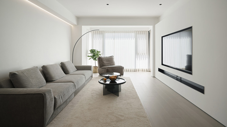 A minimalist living room decorated with gray and white furnishings