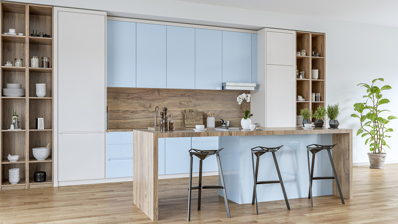 A modern kitchen with light blue cabinets and a light blue kitchen island