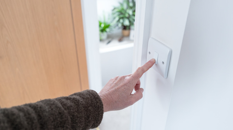 person turning off light switch
