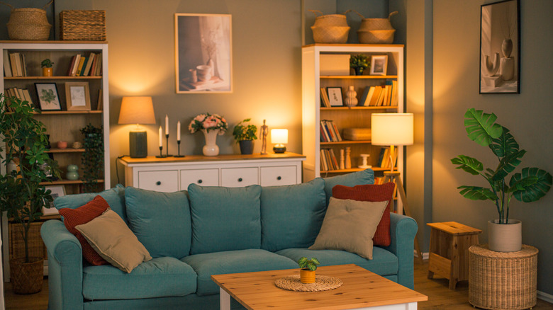 Cozy living room with blue couch and lamps turned on