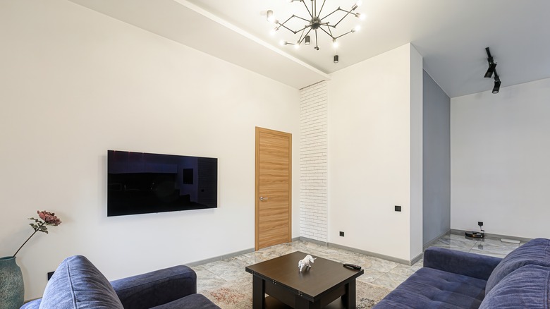 Stark living room with overhead light fixture turned on