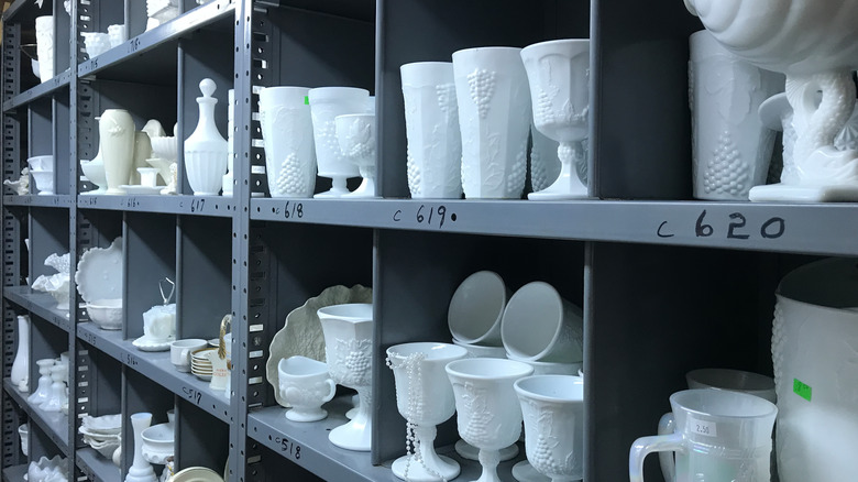 Rows of milk glass on warehouse shelves.