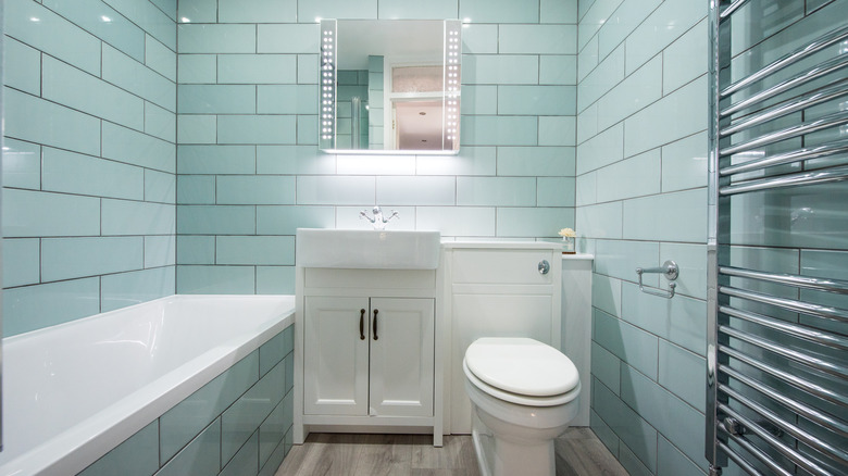 A bathroom with walls covered in sky blue tiles
