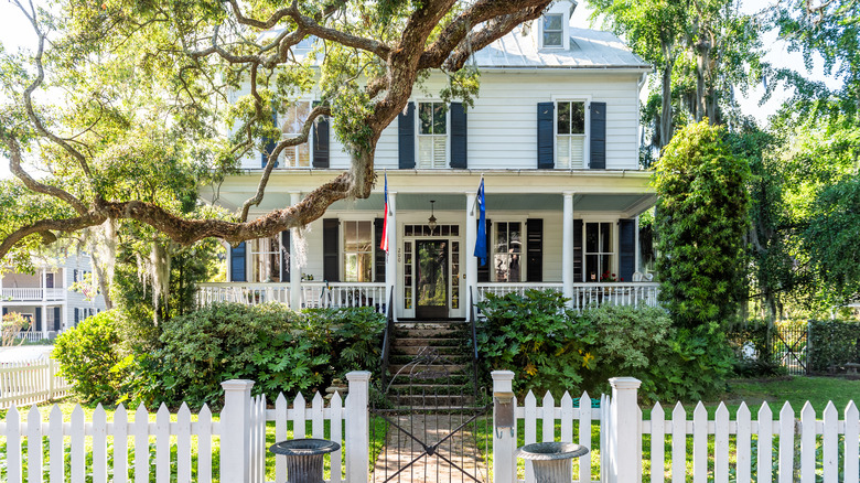 A large, historic home shaded by trees