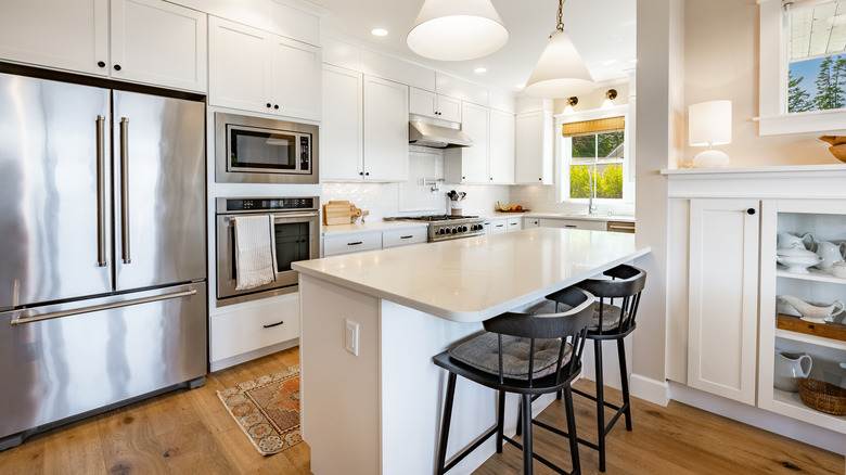 a modern white kitchen with a high-end refrigerator