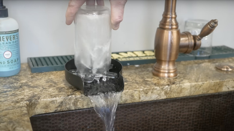 person using a glass rinser on a luxury kitchen countertop